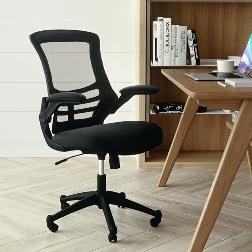 Ergonomic office chair by a desk with books and a cup.